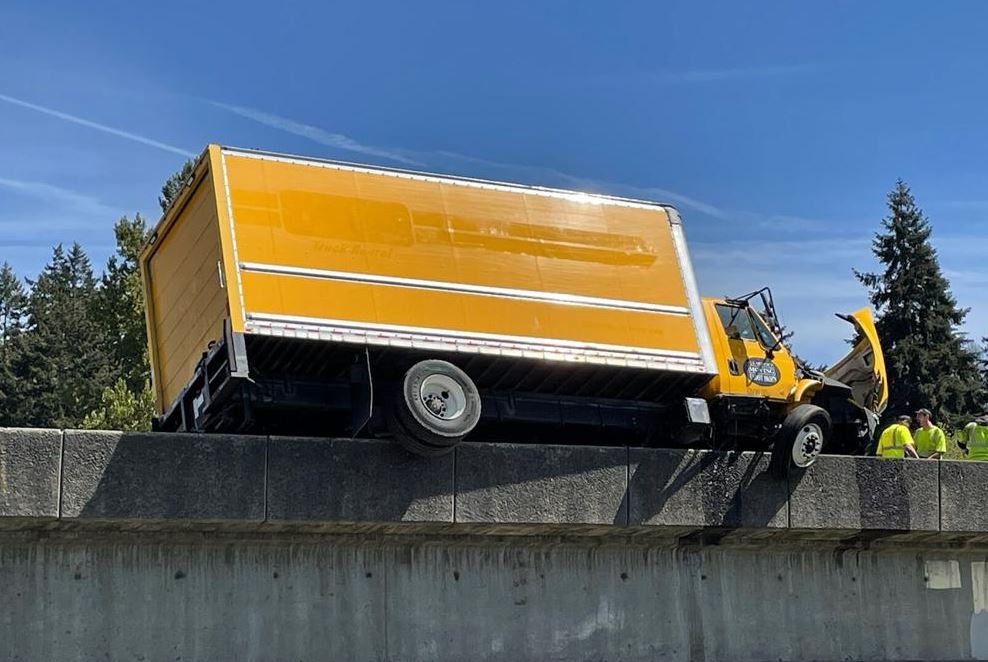 A moving truck hit a guardrail on Interstate 5 in Kelso on Tuesday and jumped the barrier on the overpass.