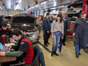 U.S. Rep. Marie Gluesenkamp Perez, second from right, joined Dannie Nordsiden of Clark College, right, on a tour of the auto shop as students work nearby in May 2023. Clark received $1 million in federal funding to develop new clean energy technician programs and classes in the school in the years to come.