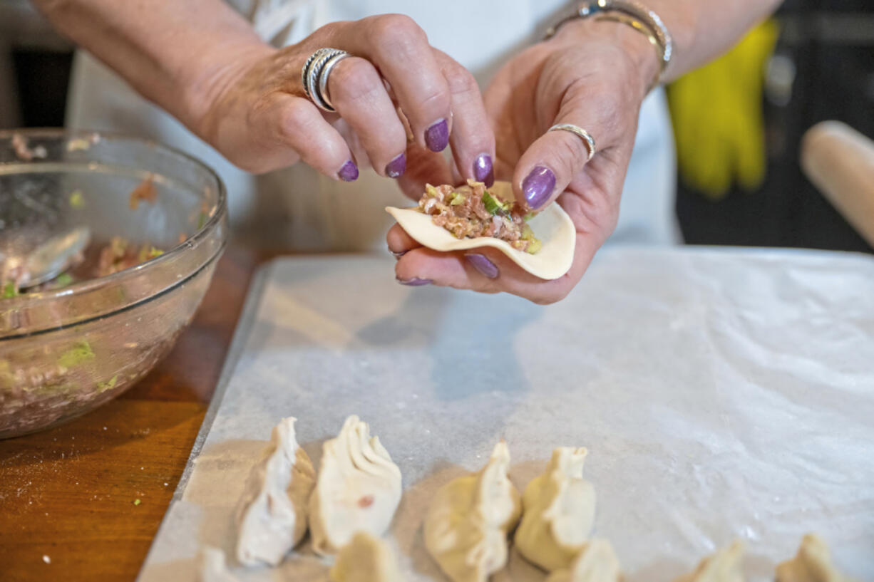 Gretchen McKay places filling in her homemade dumplings before she broils them in her kitchen in Avon, Pa. (Benjamin B.