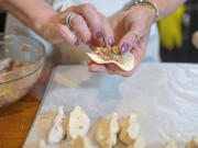 Gretchen McKay places filling in her homemade dumplings before she broils them in her kitchen in Avon, Pa. (Benjamin B.