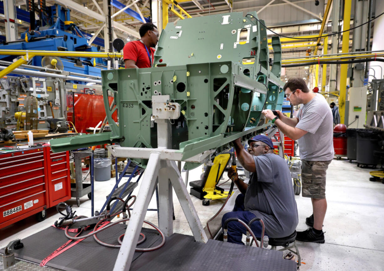 Workers assemble parts on the lower mid section of a Boeing F/A-18 Super Hornet fighter jet at the St. Louis assembly line on Aug. 10, 2022. The cockpit and seating area for the pilot can be seen at the front of the section. (David Carson/St.