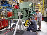 Workers assemble parts on the lower mid section of a Boeing F/A-18 Super Hornet fighter jet at the St. Louis assembly line on Aug. 10, 2022. The cockpit and seating area for the pilot can be seen at the front of the section. (David Carson/St.