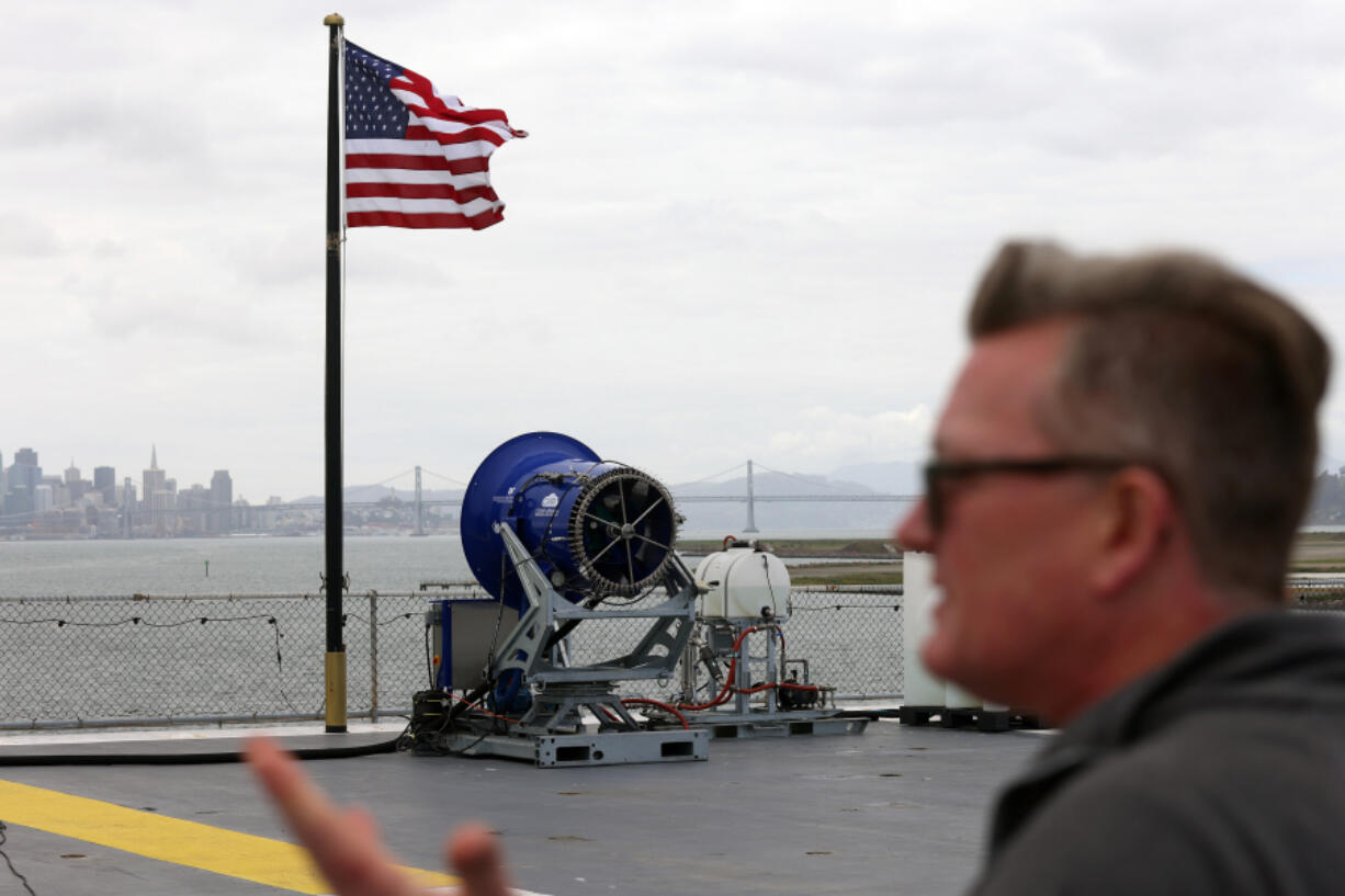 Dr. Rob Wood on the flight deck of the USS Hornet Museum with a Cloud Aerosol Research Instrument on Wednesday, April 24, 2024, in Alameda, California.