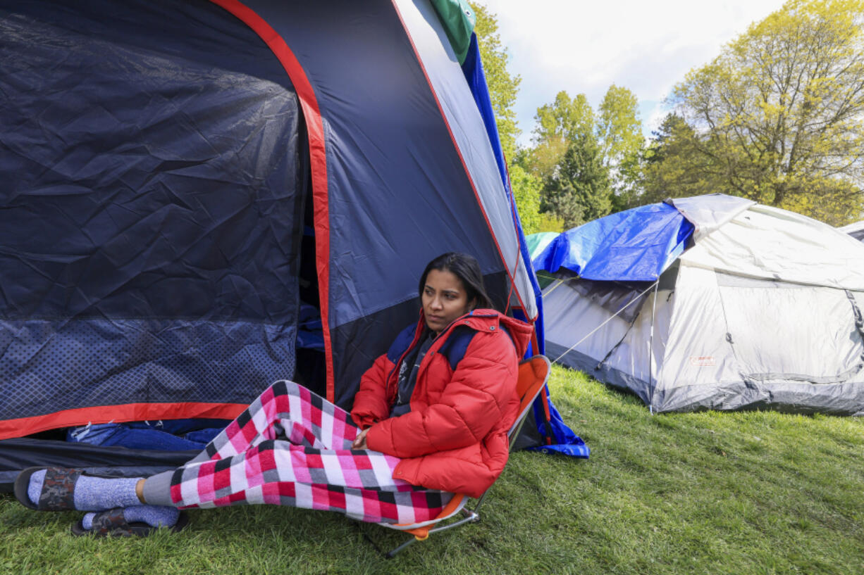 Genesis Perez, 31, who is from Venezuela and is seeking U.S. asylum, waits Tuesday by a tent that she and her family slept in overnight without access to shelter at Powell Barnett Park in Seattle.