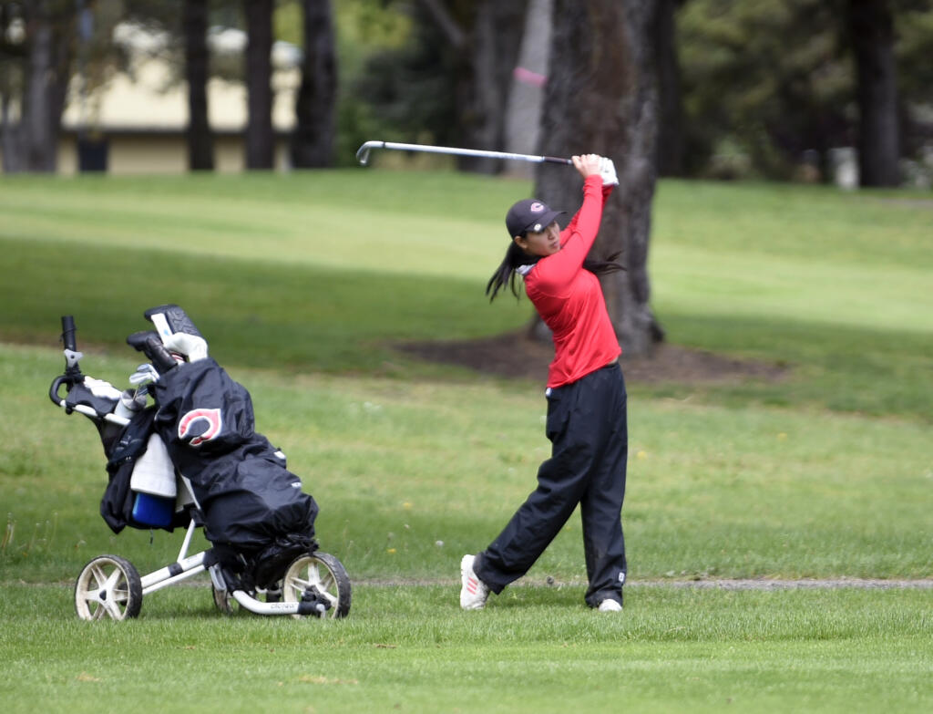 Camas' Jasmine Chen swings an iron from the fairway during the Class 4A District 4 girls golf tournament on Tuesday, May 7, 2024, at Lewis River Golf Course.