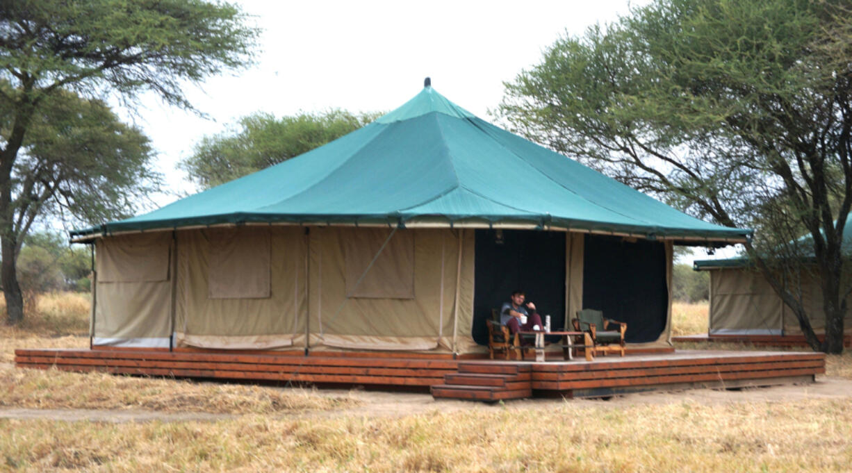 A guest warms up with complimentary tea on the veranda of his tent at the Honeyguide Tarangire Camp in Tanzania. Luxury safari lodge interest has grown 110 percent, with trending adventure travel destination Tanzania growing 60 percent year over year.