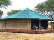 A guest warms up with complimentary tea on the veranda of his tent at the Honeyguide Tarangire Camp in Tanzania. Luxury safari lodge interest has grown 110 percent, with trending adventure travel destination Tanzania growing 60 percent year over year.