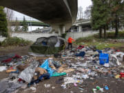 Andrea Suarez dismantles a tent as garbage lies piled at a homeless encampment on March 13, 2022 in Seattle, Washington. More than 16,000 people were reported to be experiencing homelessness on a given day in King County in the 2024 Point-in-Time Count. That is the largest number ever reported in Seattle and King County using the biennial snapshot, which is required by the federal government.