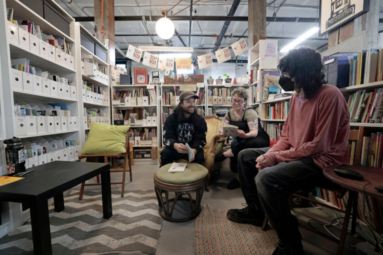 The zine library at the Soapbox, a West Philly community print shop. Studio coordinator Matao Dreskin, from left, board president Karen Lowry and fellow Belle Handler sit among the zines.