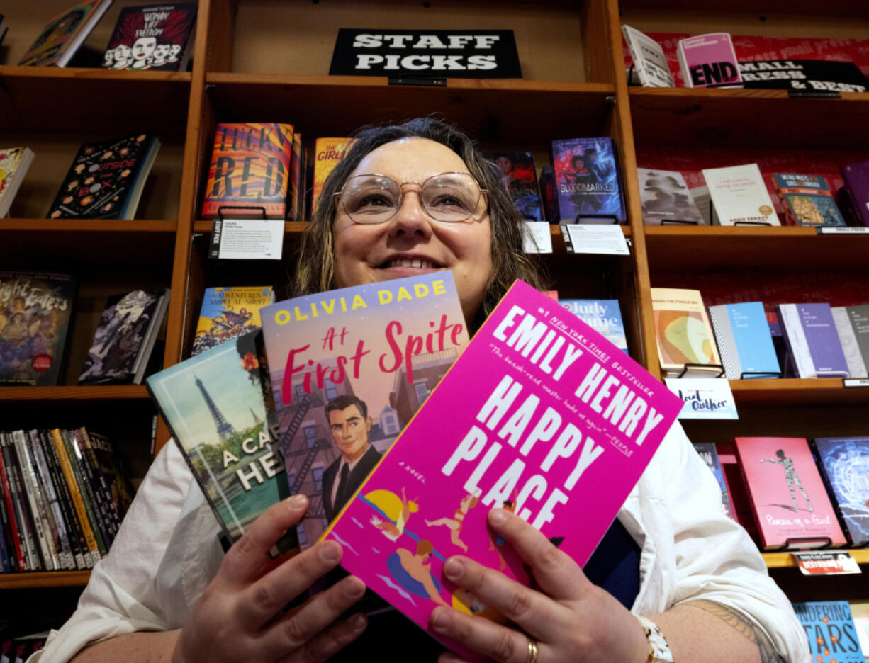 Bookseller Andrea Pangilinan has expanded the romance book section at Third Place Books Seward Park in Seattle. Pangilinan holds several of her current favorite titles on April 2.