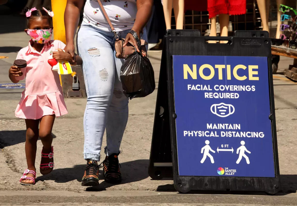 A young shopper, wearing a mask to protect herself from the coronavirus, shops with her mother on Santee Alley in the Garment District in downtown Los Angeles in June 2020. The pandemic accelerated mistrust in government, institutions &Ccedil;&fnof;&Oacute; and science .