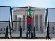 A pro-choice demonstrator yells after chaining himself to the temporary security fencing outside the US Supreme Court in Washington, D.C., on June 6, 2022.