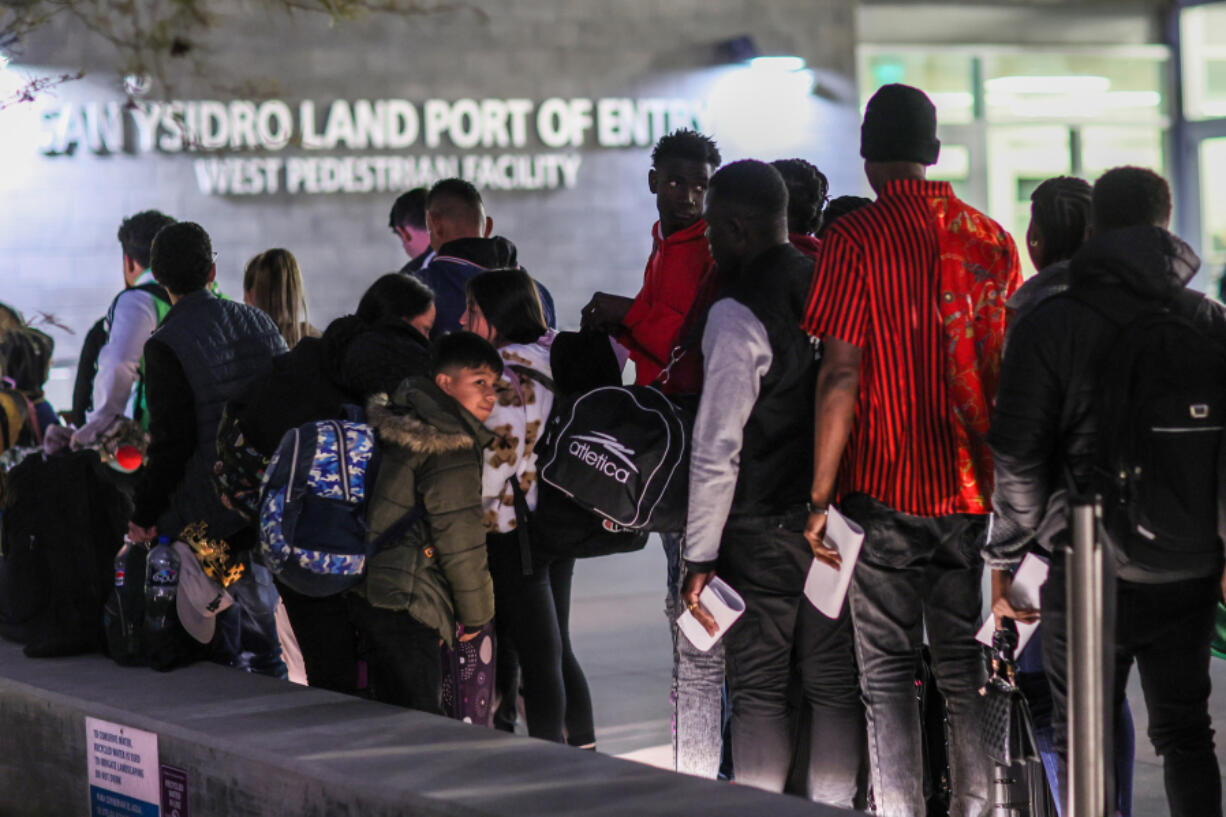 ,Asylum applicants line up for a bus after crossing from Mexico on Thursday, April 25, 2024, in San Ysidro, California.