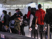 ,Asylum applicants line up for a bus after crossing from Mexico on Thursday, April 25, 2024, in San Ysidro, California.