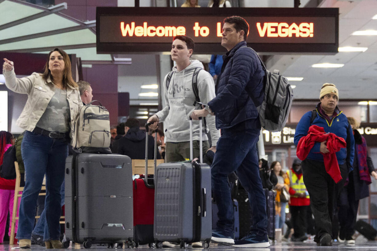 People arrive to the baggage claim area of Terminal 1 at Harry Reid International Airport in Las Vegas.