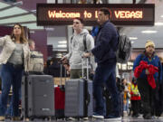 People arrive to the baggage claim area of Terminal 1 at Harry Reid International Airport in Las Vegas.