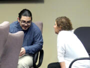 Julio Segura, 23, of Yakima speaks with his defense team Thursday before the start of the 12th day of his murder trial in Clark County Superior Court. Segura is accused in the death of off-duty Vancouver police Officer Donald Sahota.