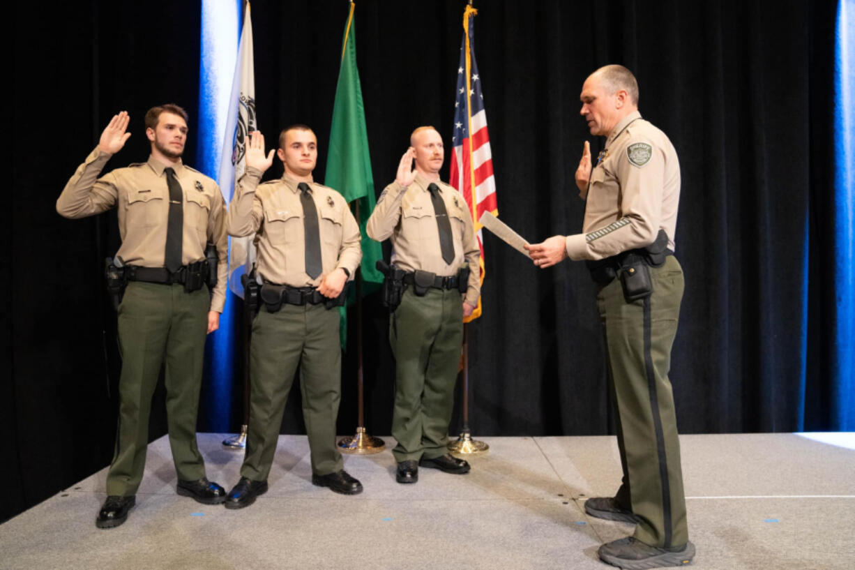 Clark County Sheriff John Horch, right, swears in new recruits, from left, Deputies Nathan Smith, Caleb Madarieta and Ryan Bylsma after they graduated May 21 from the regional law enforcement training academy in Vancouver during a ceremony at ilani. The new deputies were part of the first graduating class from the Vancouver academy, which opened in January at the former location of Image Elementary School.