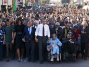 FILE - In this March 7, 2015, file photo, President Barack Obama, center, walks as he holds hands with Amelia Boynton Robinson, who was beaten during &quot;Bloody Sunday,&quot; as the first family and others including Rep. John Lewis, D-Ga., left of Obama, walk across the Edmund Pettus Bridge in Selma, Ala., for the 50th anniversary of &quot;Bloody Sunday,&quot; a landmark event of the civil rights movement. From front left are Michelle Obama's mother, Marian Robinson, Sasha Obama, first lady Michelle Obama, Obama, Boynton and Adelaide Sanford, also in wheelchair.  Michelle Obama announced Friday that her mother died at age 86.