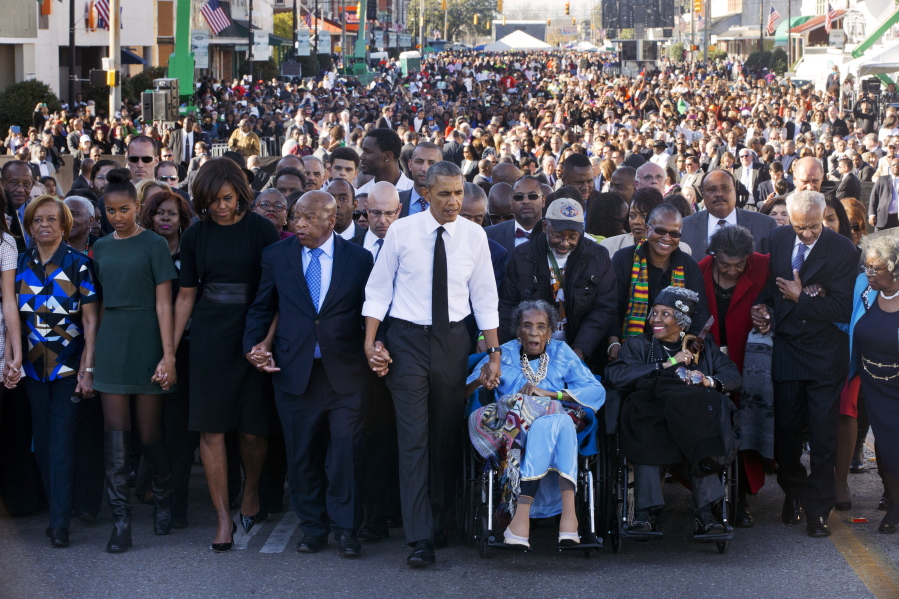 FILE - In this March 7, 2015, file photo, President Barack Obama, center, walks as he holds hands with Amelia Boynton Robinson, who was beaten during &quot;Bloody Sunday,&quot; as the first family and others including Rep. John Lewis, D-Ga., left of Obama, walk across the Edmund Pettus Bridge in Selma, Ala., for the 50th anniversary of &quot;Bloody Sunday,&quot; a landmark event of the civil rights movement. From front left are Michelle Obama's mother, Marian Robinson, Sasha Obama, first lady Michelle Obama, Obama, Boynton and Adelaide Sanford, also in wheelchair.  Michelle Obama announced Friday that her mother died at age 86.