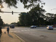 A pedestrian walks with a dog at the intersection of South Stony Island Avenue and East 63rd Street where the ShotSpotter technology is in use above the crossroads on Tuesday, Aug. 10, 2021, in Chicago.