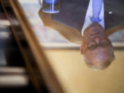 Washington Gov. Jay Inslee is reflected in a table as he prepares in his office before his State of the State address on the second day of the legislative session at the Washington state Capitol, Tuesday, Jan. 9, 2024, in Olympia, Wash.