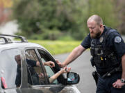 Vancouver police Officer Cole Larson talks with a motorist before confiscating a device used to smoke fentanyl and issuing a citation on April 4. Therapeutic drug courts have seen lower participation since decriminalization of drug possession.