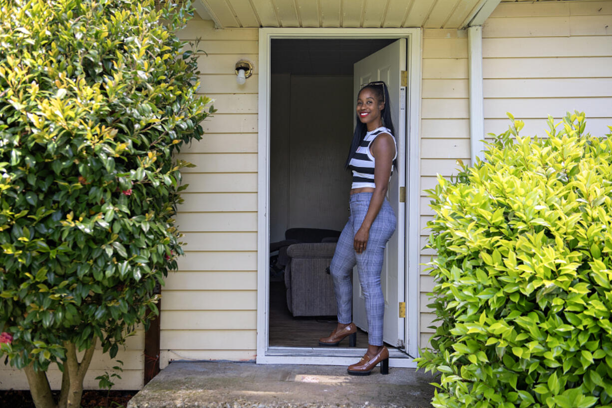 Genevieve Fisher of Vancouver takes a break May 16 in front of the house she purchased with her mother that provides shelter for people dealing with mental health issues and chronic homelessness.