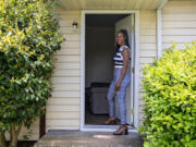 Genevieve Fisher of Vancouver takes a break May 16 in front of the house she purchased with her mother that provides shelter for people dealing with mental health issues and chronic homelessness.