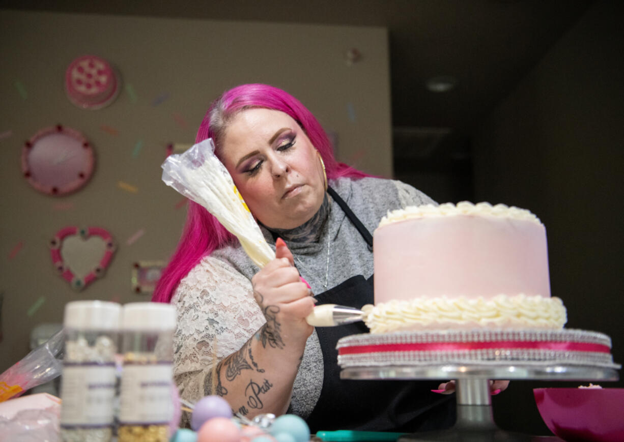 Jenn Hubbard decorates a cake May 21 at Hubbard&rsquo;s house in Vancouver. Hubbard began baking after her diabetic daughter beat kidney cancer and she wanted to make her a custom cake to celebrate.