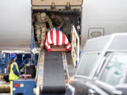 Soldiers and airport personnel carefully move a casket containing the remains of U.S. Army Air Forces Technician Fourth Grade Herbert F. March of La Center on May 4 at Portland International Airport.