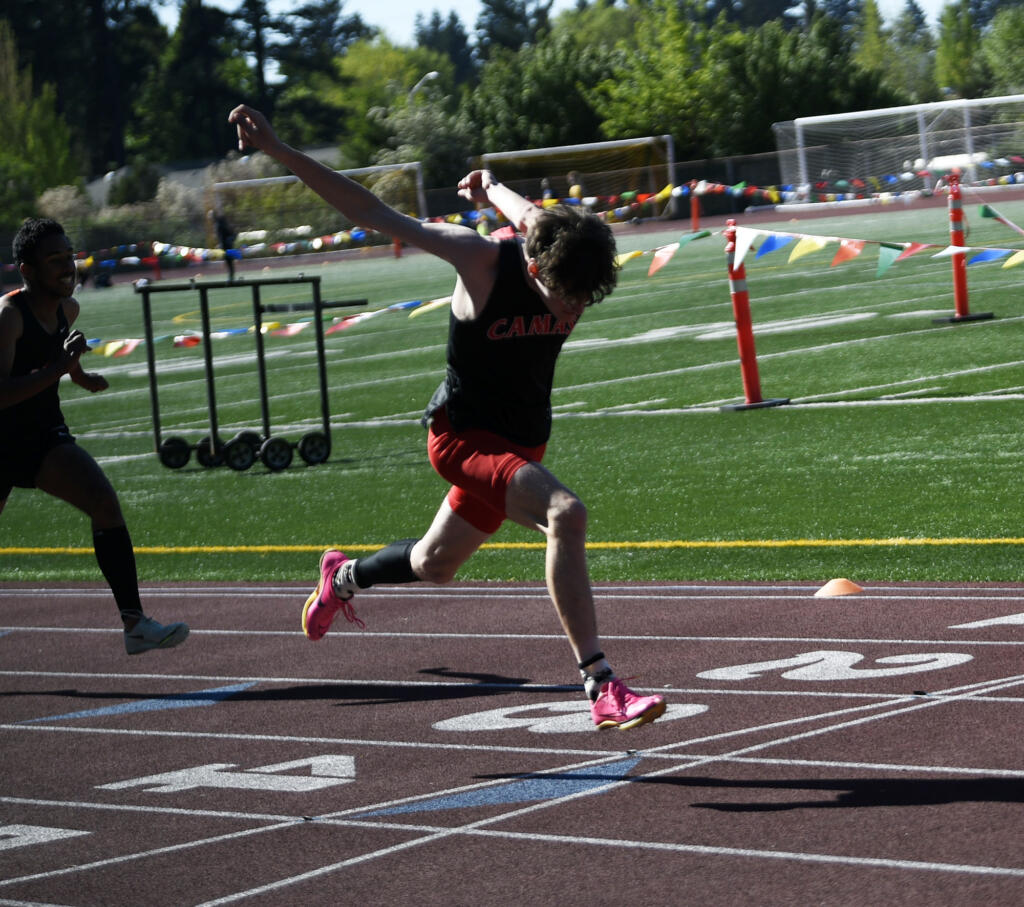 Max Ensinger of Camas reaches for the finish line to win the 4A boys 110-meter hurdles at the 4A/3A Greater St. Helens League district track and field meet at McKenzie Stadium on Wednesday, May 8, 2024.