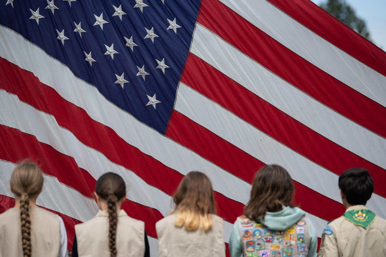 Local Girl Scouts and Boy Scouts gather to help raise the American flag at the beginning of Monday&rsquo;s annual Memorial Day Remembrance event at the Fort Vancouver National Historic Site parade grounds.