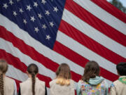 Local Girl Scouts and Boy Scouts gather to help raise the American flag at the beginning of Monday&rsquo;s annual Memorial Day Remembrance event at the Fort Vancouver National Historic Site parade grounds.