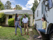 Genevieve Fisher of Vancouver, from left, takes a break in the front yard of the house she purchased with her mom while joined by tenants Stephaun Gallaread and Helen Lowdermilk.