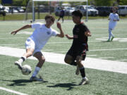 King's Way Christian's Ryan Tyler, left, tries to avoid Columbia-White Salmon's Matthew Carillo during the Class 1A boys soccer District 4 championship match on Saturday, May 11, 2024 at Seton Catholic High School.