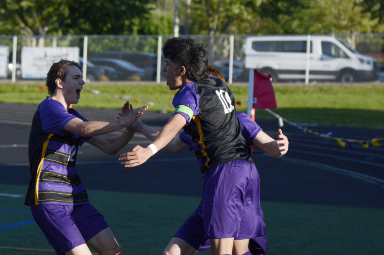 Columbia River&rsquo;s J.P. Guzman (10) celebrates his first goal against Renton in the Class 2A boys soccer state playoffs with teammates Evan Roscoe, left, and Ryland Perron, back, on Tuesday, May 14, 2024 at Columbia River High School.