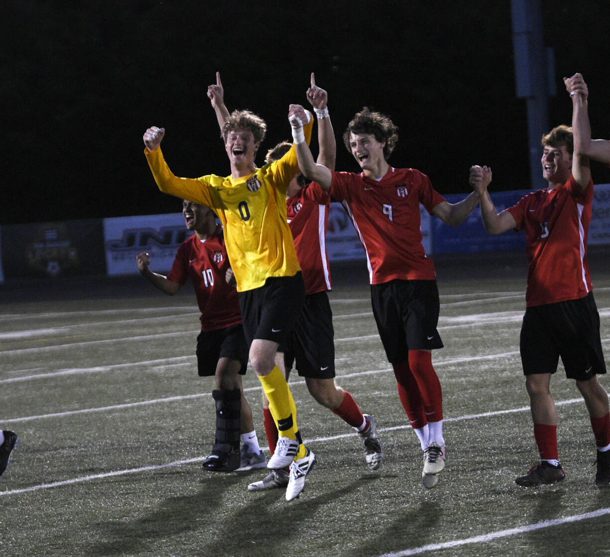 Camas players Jack Odone (0) and Cooper Schneider (9) celebrate with teammates after the Papermakers' 3-2 win over Mount Rainier in a Class 4A state boys soccer round-of-16 game at Doc Harris Stadium in Camas on Tuesday, May 14, 2024.