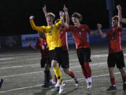 Camas players Jack Odone (0) and Cooper Schneider (9) celebrate with teammates after the Papermakers' 3-2 win over Mount Rainier in a Class 4A state boys soccer round-of-16 game at Doc Harris Stadium in Camas on Tuesday, May 14, 2024.