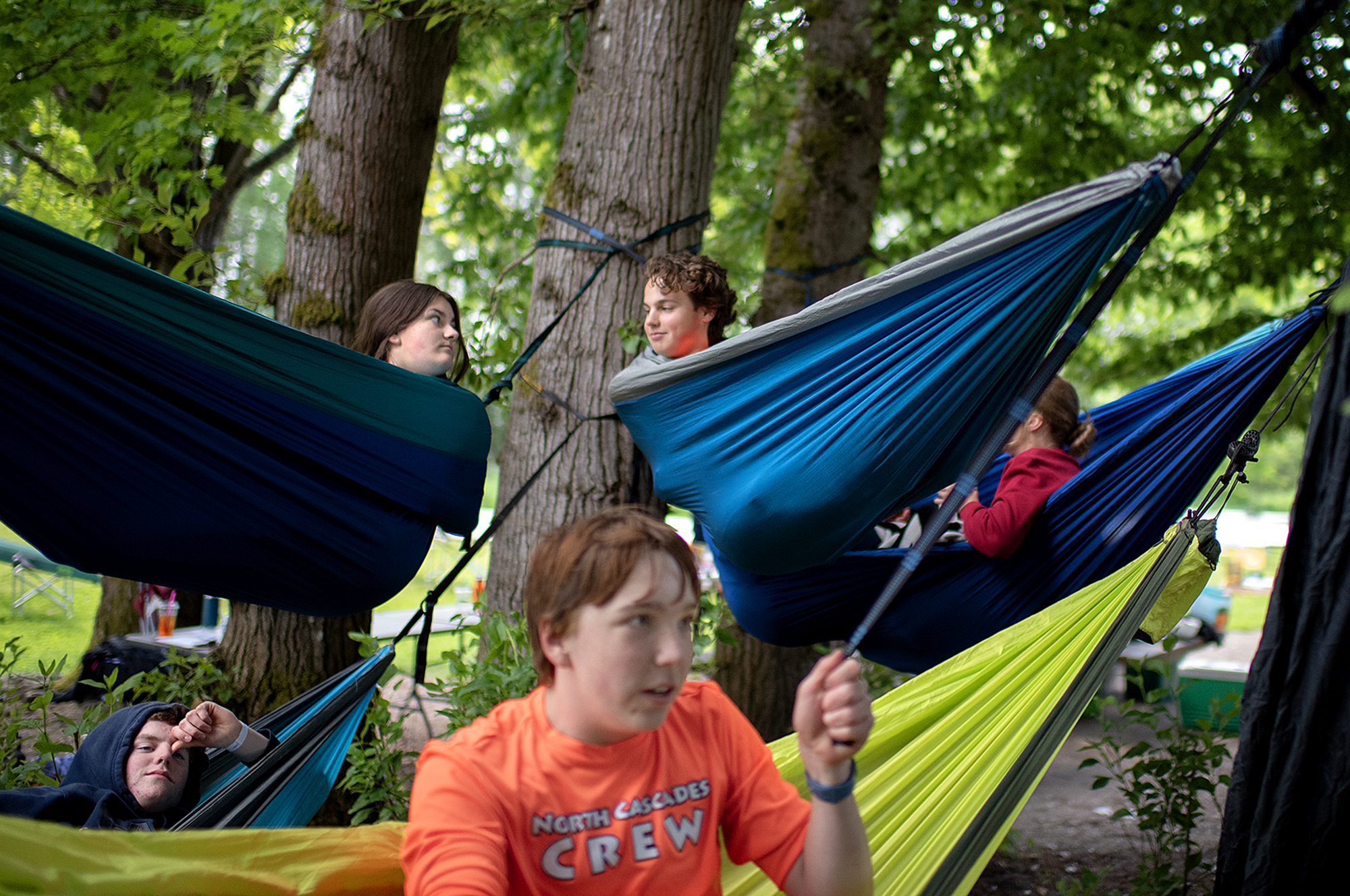 Members of North Cascade Crew relax in hammocks during a break from the action during the U.S. Rowing Northwest Youth Championships at Vancouver Lake on Friday morning, May 17, 2024.
