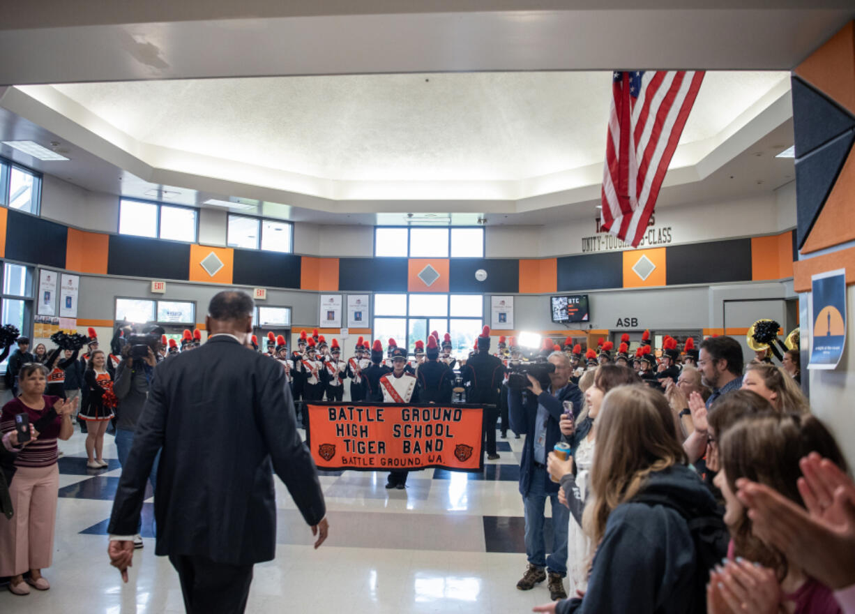 Battle Ground music director Greg McKelvey, left, walks down the main hallway of Battle Ground High School as people cheer on Wednesday at Battle Ground High School. McKelvey, who&rsquo;s worked at the school since 1996, has been named grand marshal of the 2024 Portland Rose Festival Grand Floral Parade.