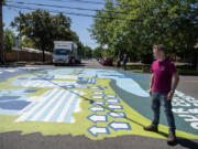 Artist Benji Todd looks over the new mural highlighting pedestrian safety he created in downtown Vancouver.