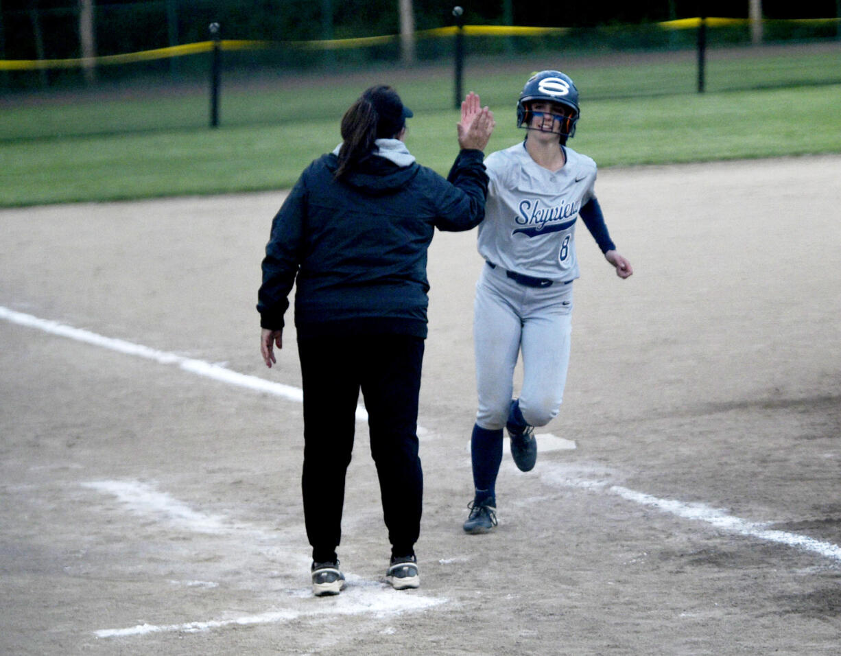 Skyview's Lainey Phillips, right, is congratulated by coach Kim Anthony after hitting a home run in the sixth inning of a quarterfinal game against South Kitsap in the Class 4A District 3/4 tournament on Friday, May 17, 2024 in Kent.