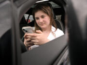 Alexis Bogan, whose speech was impaired by a brain tumor, uses an AI powered smartphone app to create a audible drink order at a Starbucks drive-thru on Monday, April 29, 2024, in Lincoln, R.I. The app converts her typed entries into a verbal message created using her original voice.