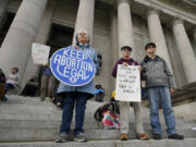 People hold signs in favor of abortion rights as they stand on the steps of the Temple of Justice, which houses the Washington state Supreme Court, during an evening rally, Tuesday, May 3, 2022, at the Capitol in Olympia, Wash. (AP Photo/Ted S.