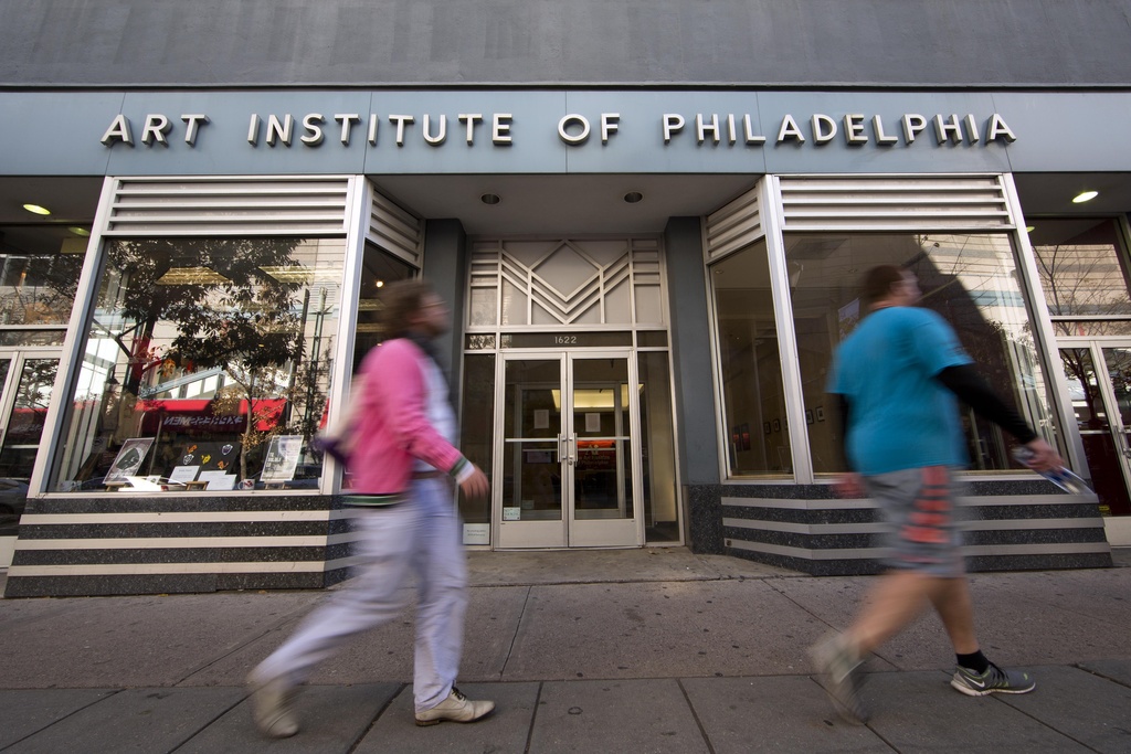 FILE - People walk past the Art Institute of Philadelphia operated by the Education Management Corporation on Nov. 16, 2015, in Philadelphia. The Biden administration on Wednesday said it will cancel $6 billion in student loans for people who attended the Art Institutes, a system of for-profit colleges that closed the last of its campuses in 2023 amid accusations of fraud.