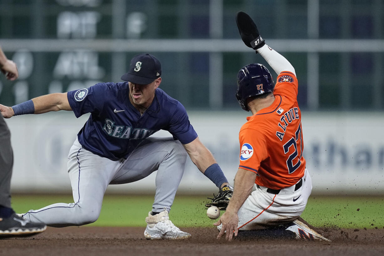 Seattle Mariners shortstop Dylan Moore misses the tag as Houston Astros' Jose Altuve steals second base during the seventh inning of a baseball game Friday, May 3, 2024, in Houston. The play was Altuve's 300th career steal. (AP Photo/Kevin M.