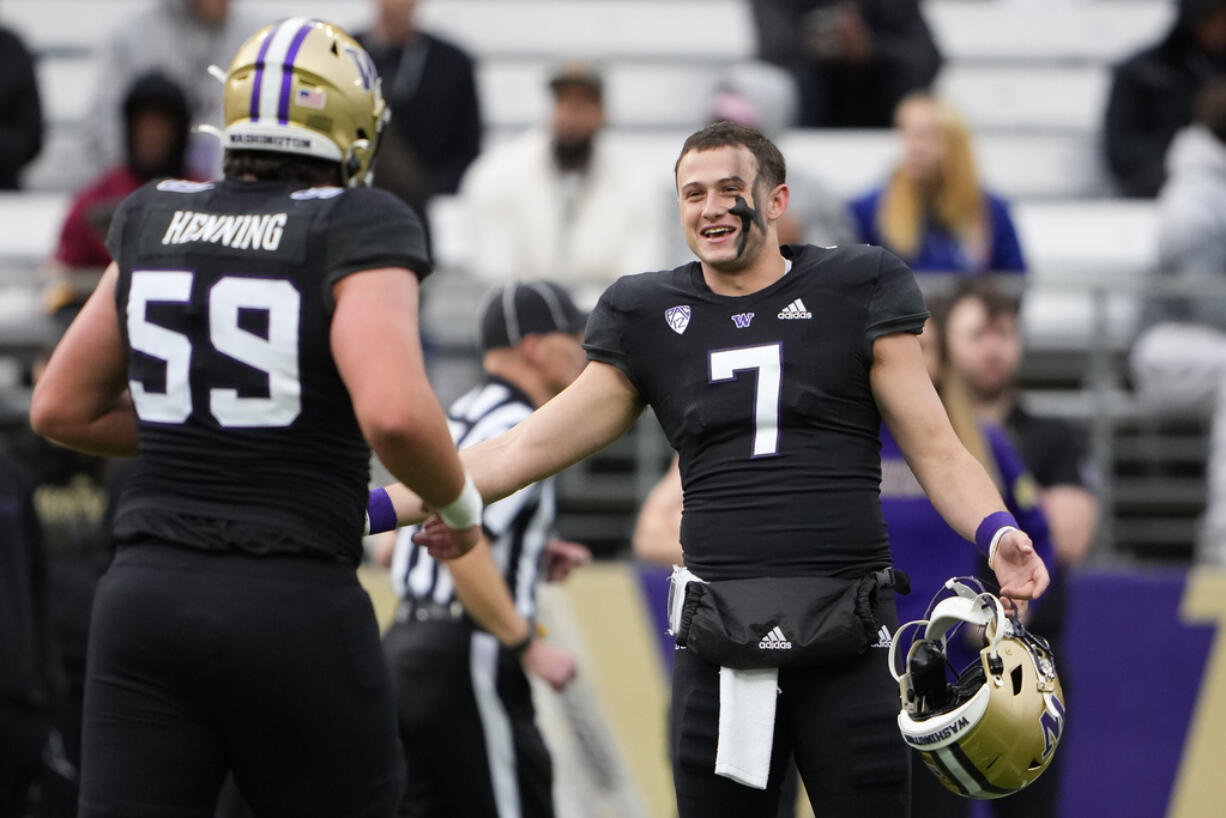 Washington quarterback Will Rogers III greets teammate Zachary Henning (59) during the NCAA college football team's spring game Friday, May 3, 2024, in Seattle.