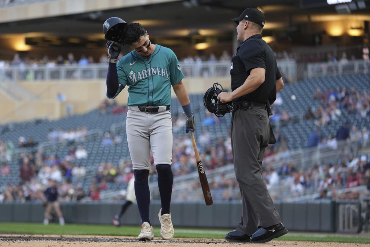 Seattle Mariners' Josh Rojas walks back to the dugout after being called out on strikes to end the top of the third inning of a baseball game against the Minnesota Twins, Monday, May 6, 2024, in Minneapolis.