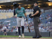Seattle Mariners' Josh Rojas walks back to the dugout after being called out on strikes to end the top of the third inning of a baseball game against the Minnesota Twins, Monday, May 6, 2024, in Minneapolis.